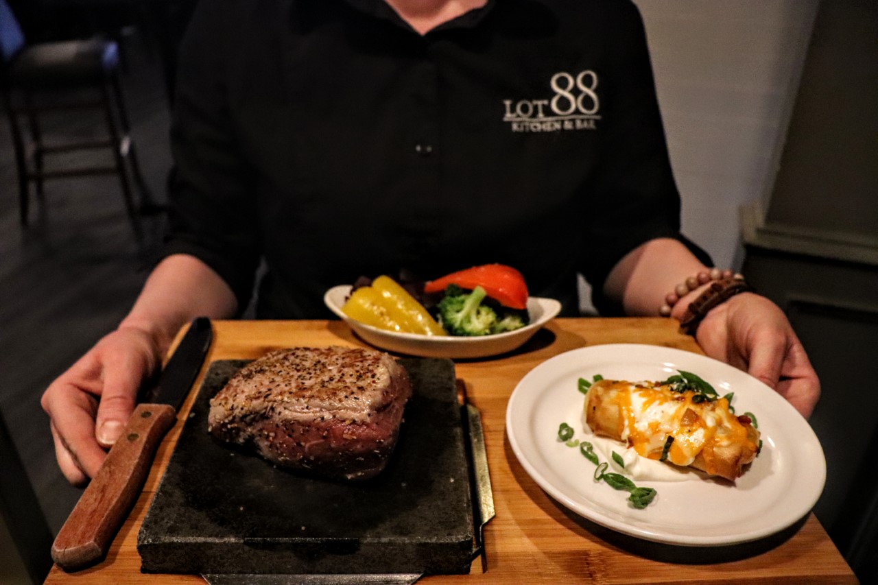 A waiter carrying a serving of food at Lot 88 one of the top restaurants in Orillia